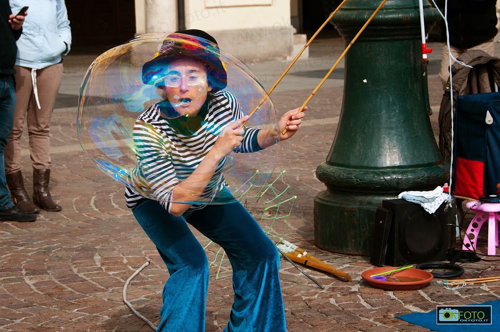 artista-strada una giovane artista affascina i bambini con le bolle di sapone