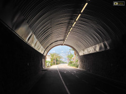 Al termine del tunnel palme e mare azzurro attendono i ciclisti